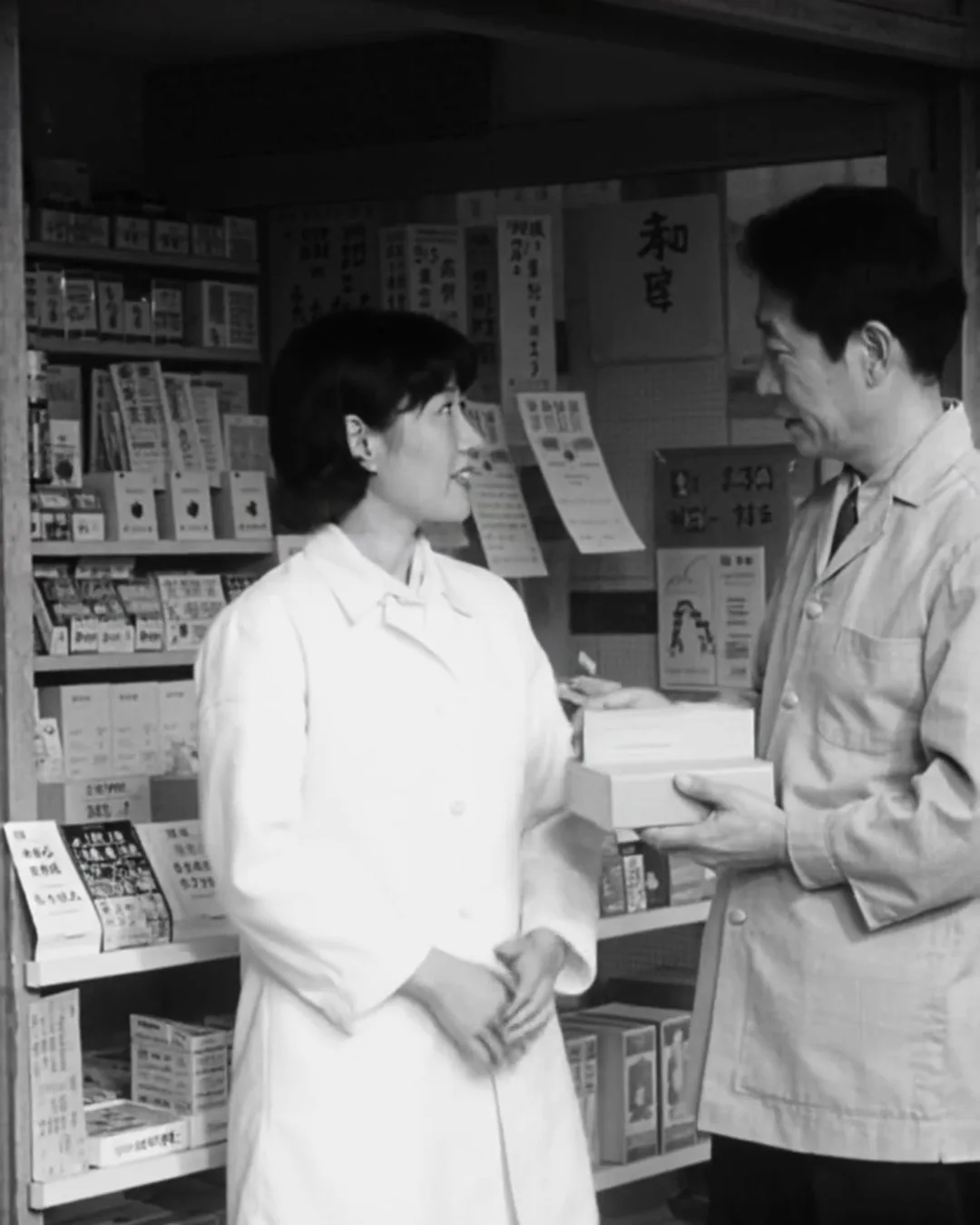 ドラッグストアの棚の前で、白衣の女性スタッフが小さな箱を持った外国人の男性客と話している