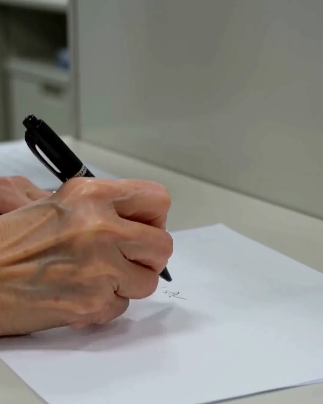 用紙に、ペンで書き込んでいる手元