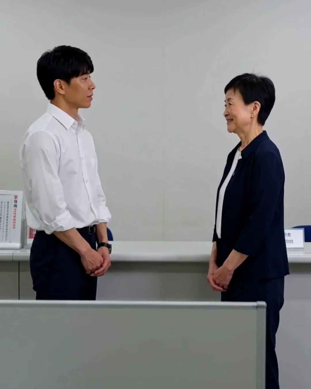 ハローワークの窓口で、相談員と外国人の男性が用紙を前に話している