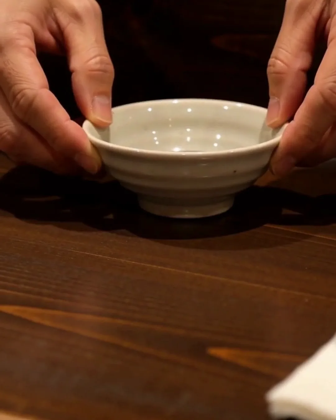 お通しの小皿を両手で差し出している手元