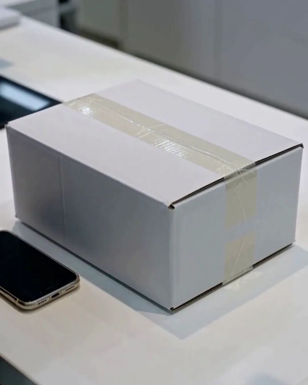 免税カウンターに置かれた、白い箱の家電とスマートフォン