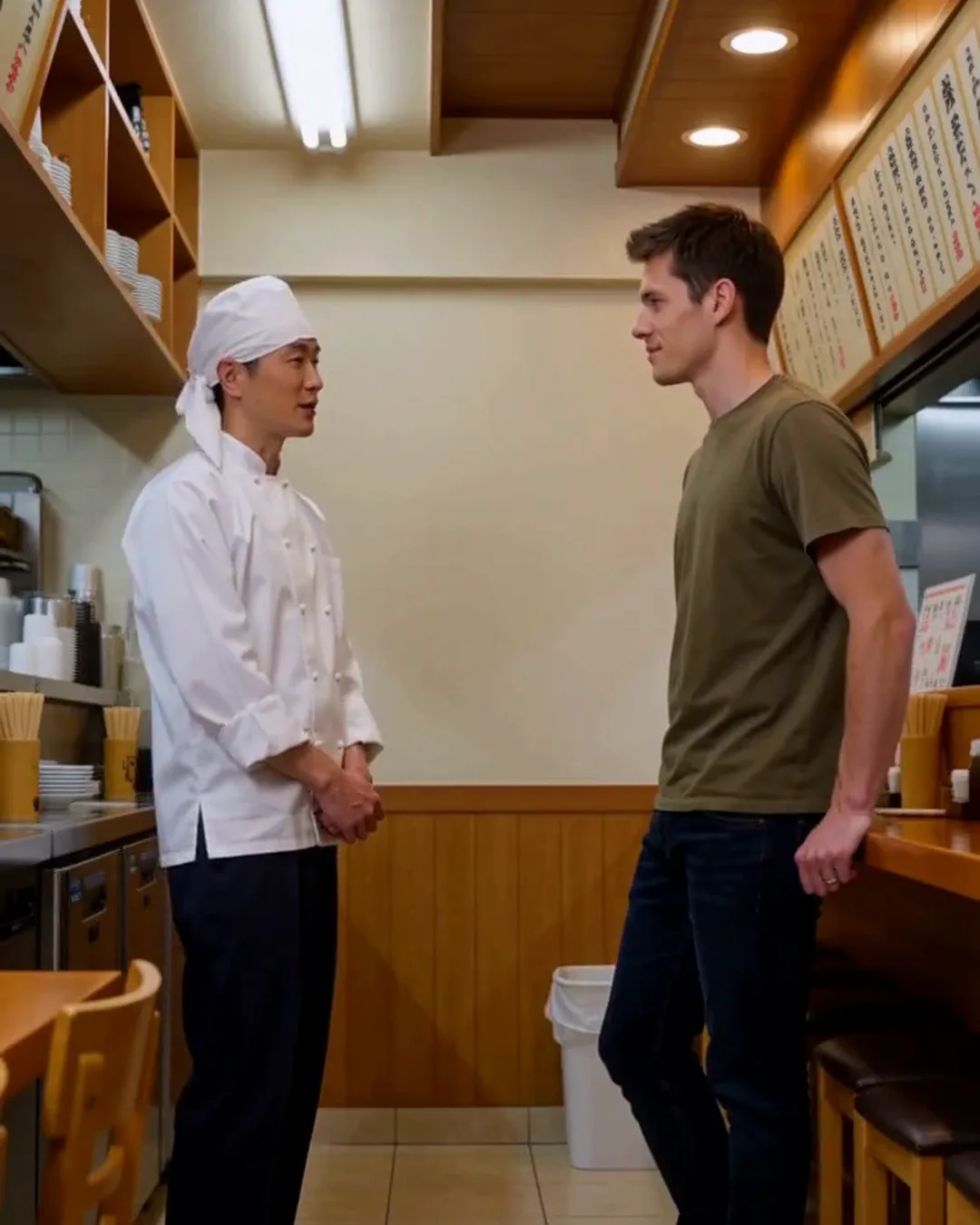 昼どきのラーメン店のカウンターで、店主と外国人の男性客が話している