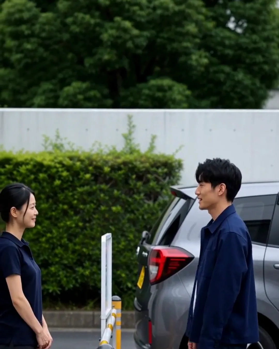 レンタカーの返却レーンで、スタッフの女性と外国人の男性客が車の横で話している