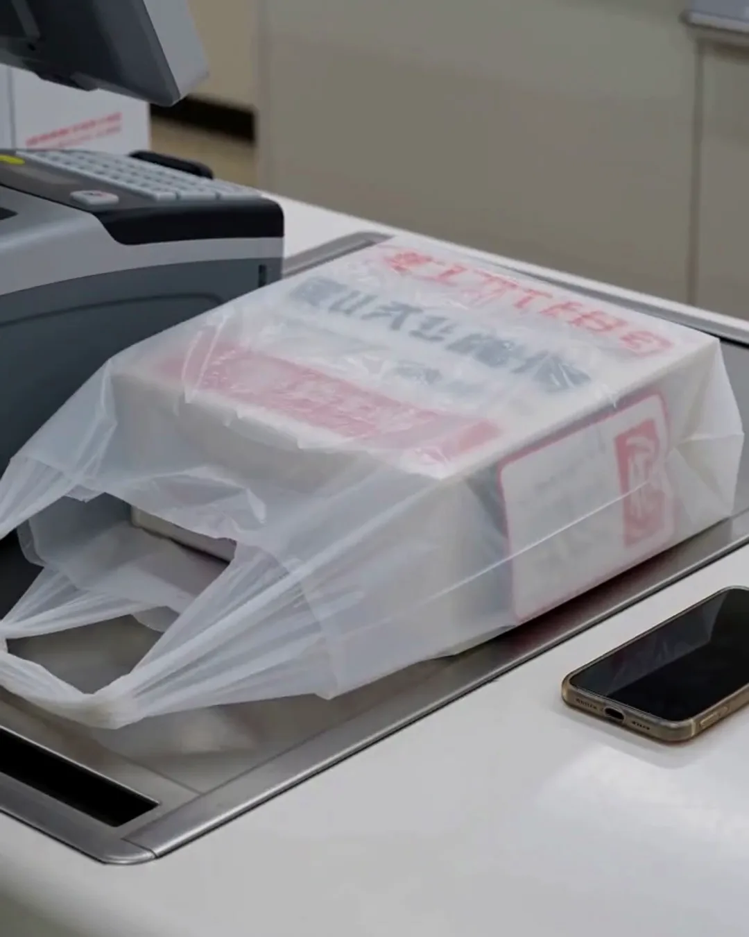 レジ台に置かれた、白いレジ袋と商品