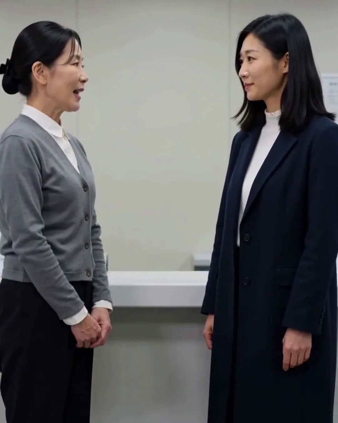 税務署の窓口で、職員と外国人の女性が書類を前に話している